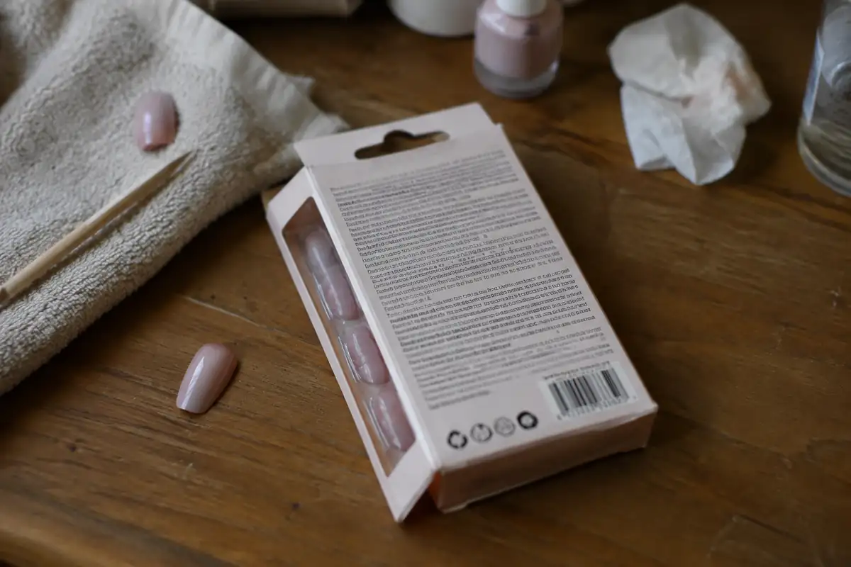 Dos d'une boîte de faux ongles avec une liste d'ingrédients illisible